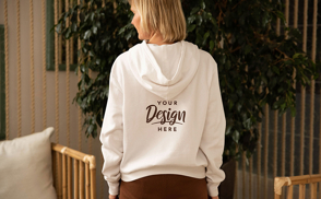 Blonde woman standing backwards with hoodie mockup