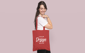 Woman smiling and holding a tote bag mockup