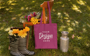 Tote bag hanging on chair with flowers mockup