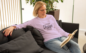 Woman reading on couch sweatshirt mockup