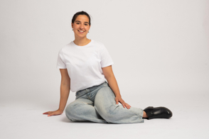 Hispanic girl sitting on the floor with t-shirt mockup