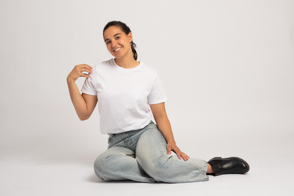 Hispanic woman sitting on the floor with t-shirt mockup