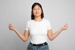 Asian female doing zen gestures in t-shirt mockup