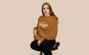 Blonde girl sitting hoodie mockup | Start Editing Online
