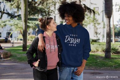 Glückliches Paar, das durch Park-Hoodie-Modell geht walking