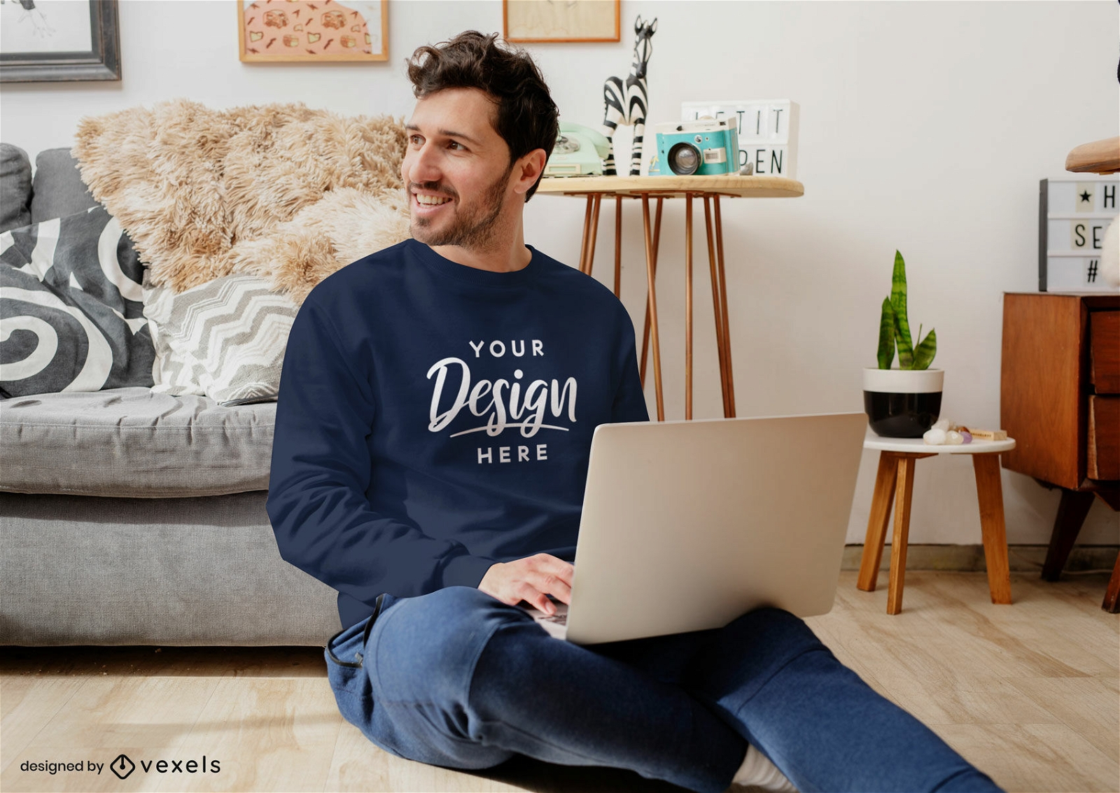 Man in living room with laptop sweatshirt mockup