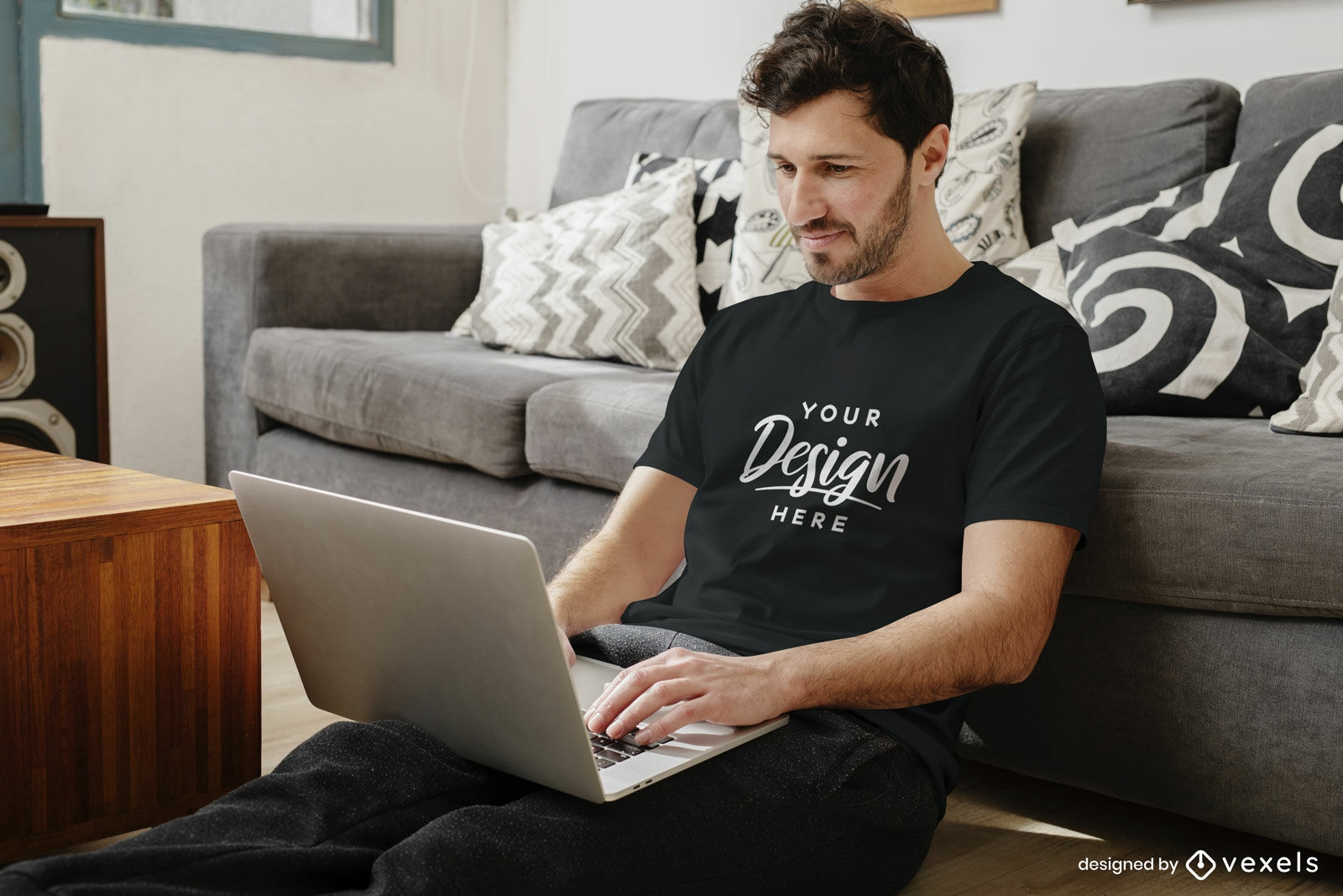 Schwarzer T-Shirt-Mockup-Mann im Wohnzimmer mit Laptop