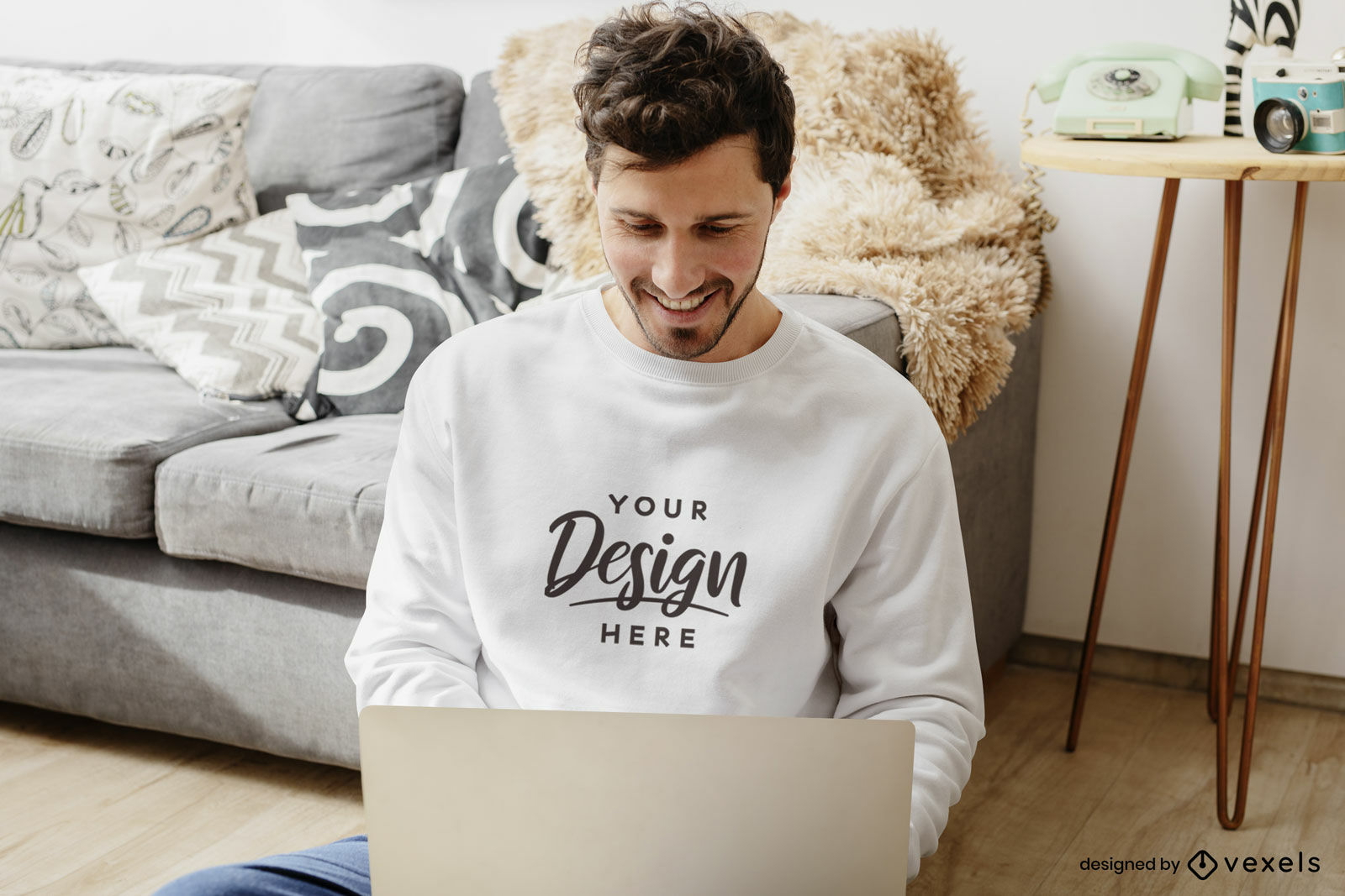 Hombre en sudadera blanca con maqueta de sala de estar portátil