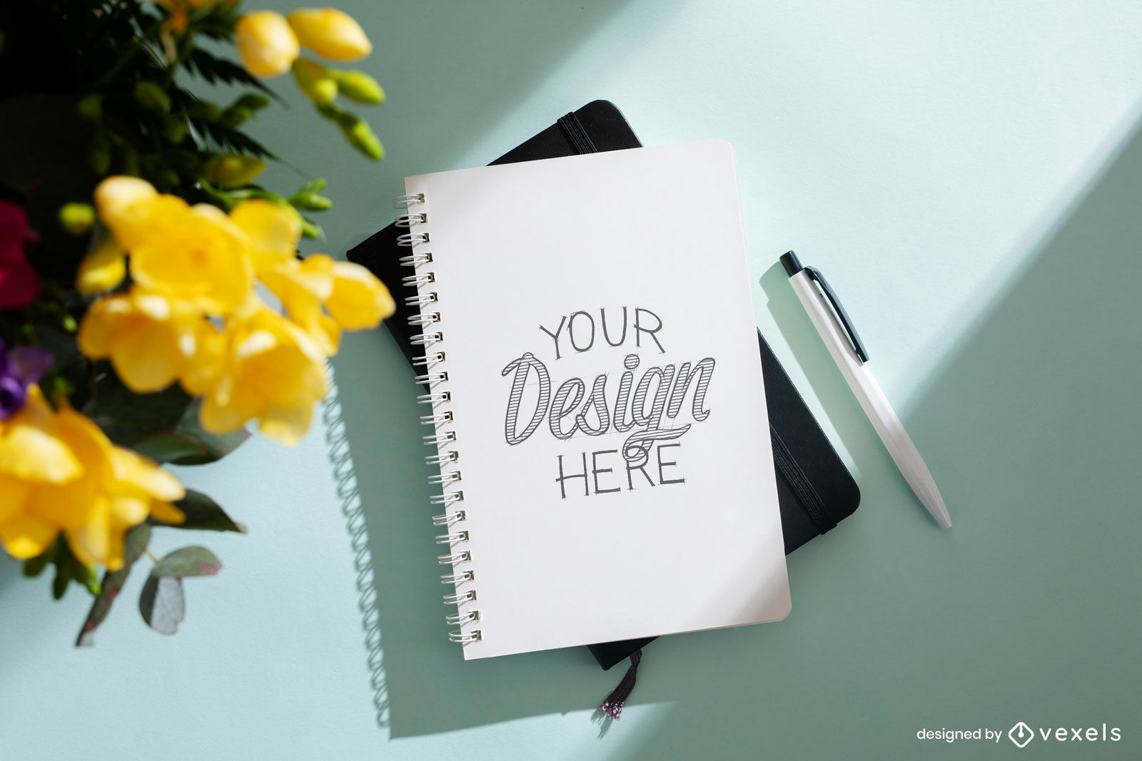 Notebook in surface with flowers mockup