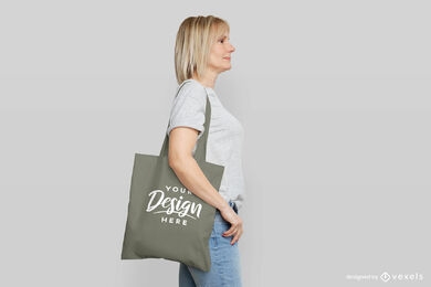 Mujer con maqueta de bolso gris en fondo plano