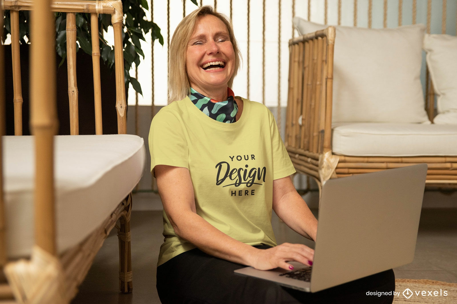 Mulher rindo com a maquete da camiseta amarela do laptop