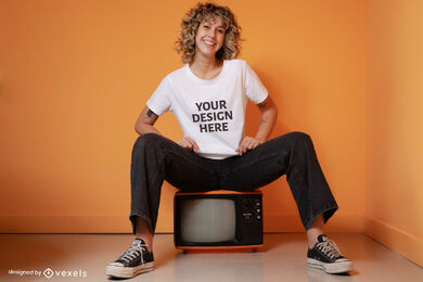 Frau, die auf altem tv-t-shirt-modell sitzt