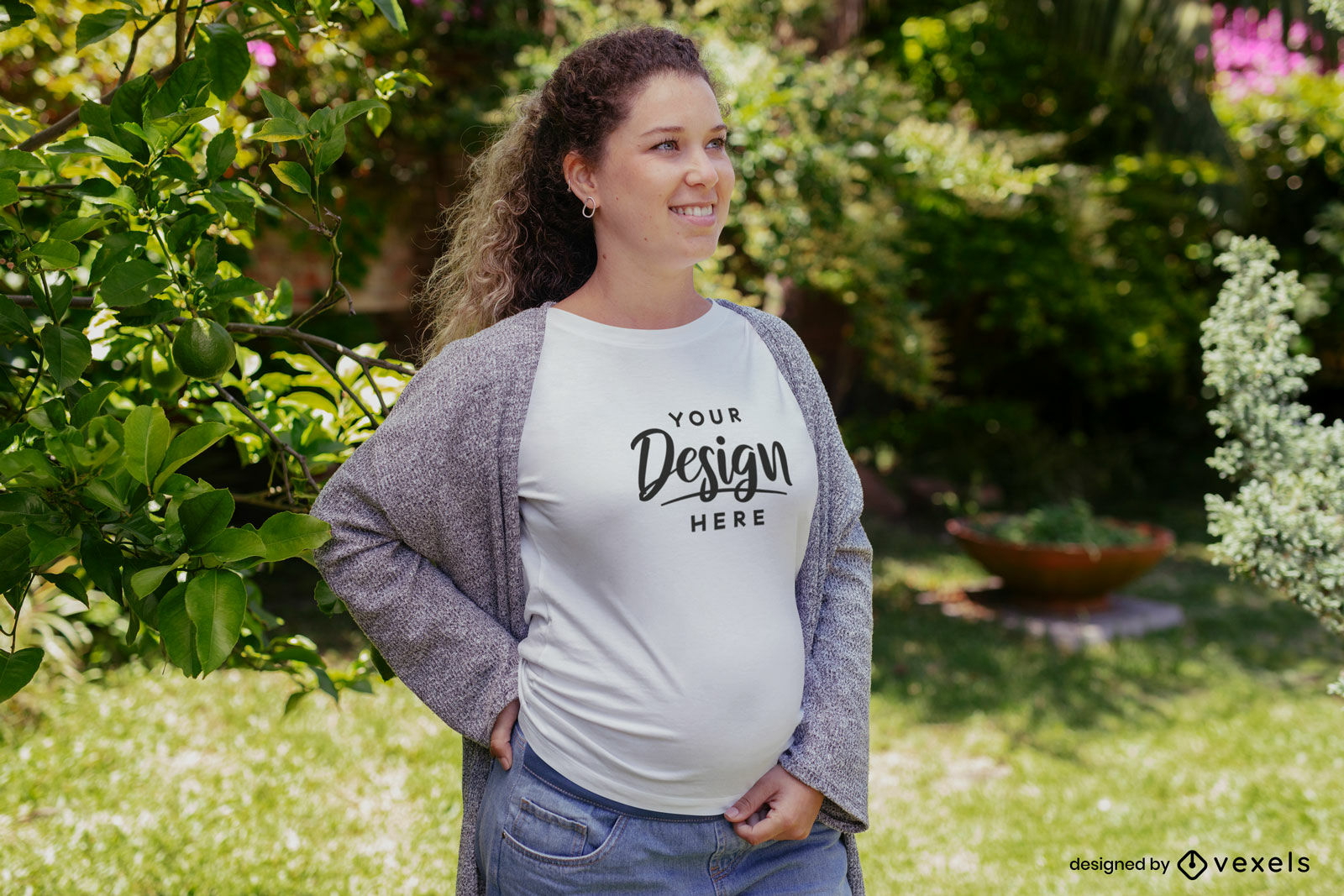 Mulher grávida com maquete de camiseta no jardim