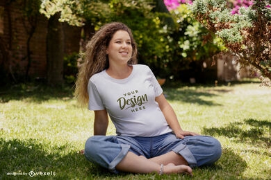 Grávida sentada em uma maquete de camiseta no jardim