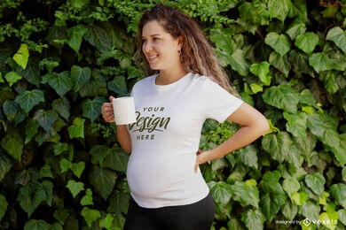 Modelo embarazada femenina con maqueta de camiseta de taza