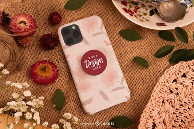 Phone case on table with leaves and flowers mockup