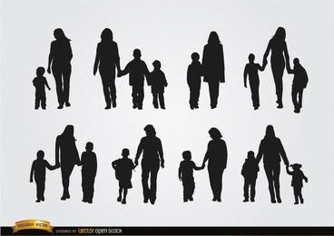 Mothers walking with sons silhouettes