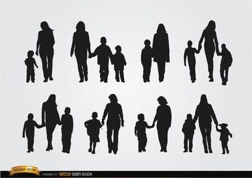 Mütter gehen mit Söhnen Silhouetten